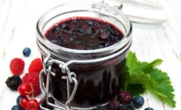 Jam and fresh berries on a wooden background